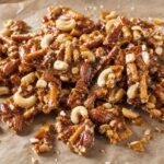 Amber beer brittle shards with mini pretzel pieces and mixed roasted nuts on parchment