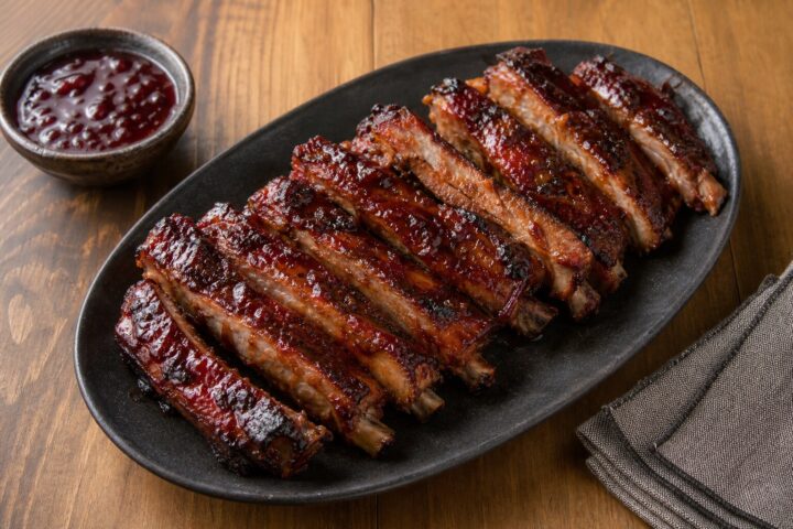 Cherry cola glazed pork spareribs with a glossy caramelized cherry and mustard coating on a serving platter