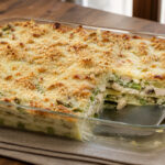 Golden baked lasagna layered with chicken, asparagus, mushrooms, creamy pesto sauce, and melted mozzarella