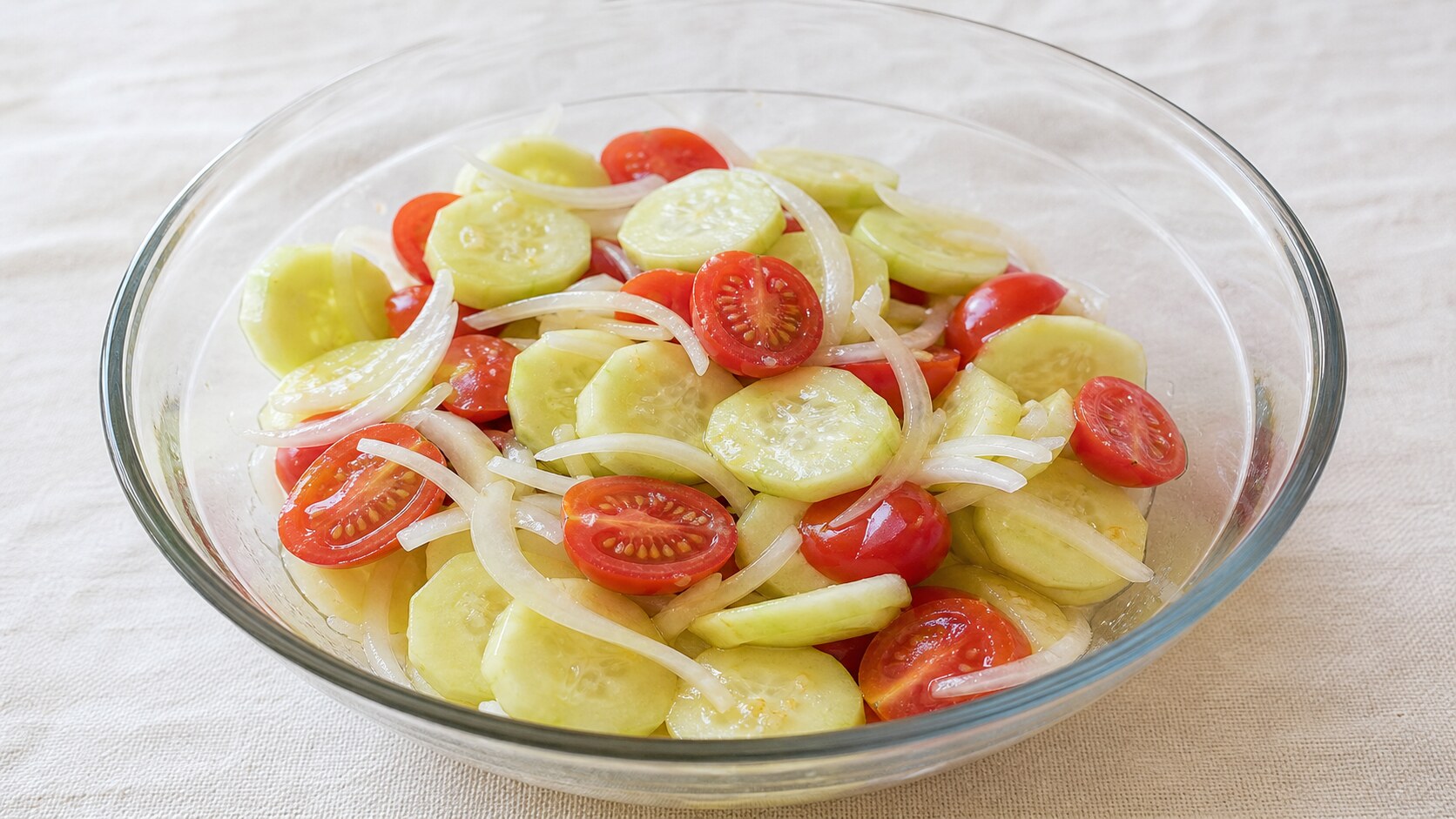 Cucumber tomato and onion salad with peeled cucumber slices, halved cherry tomatoes, and sweet onion in vinaigrette