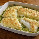 Halibut Olympia fillets baked with green onions under a creamy Parmesan topping in a serving dish